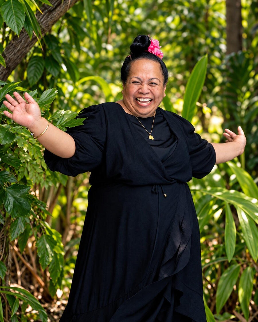 Beyond Work photo Vienna Senima Richards laughing with her arms open in a tropical garden